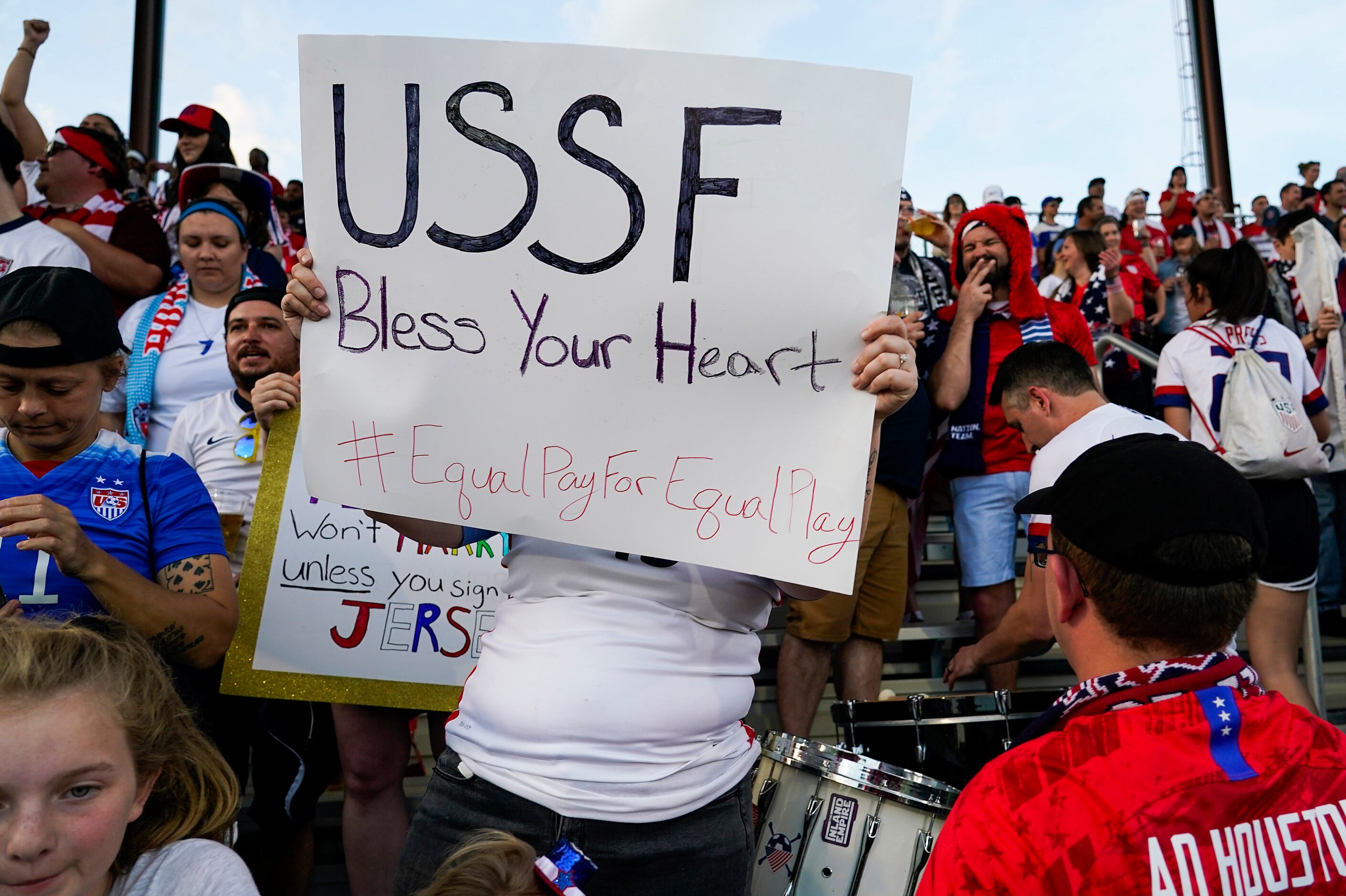 A USA fan holds a sign calling for equal pay for the womenÕs national team before a...