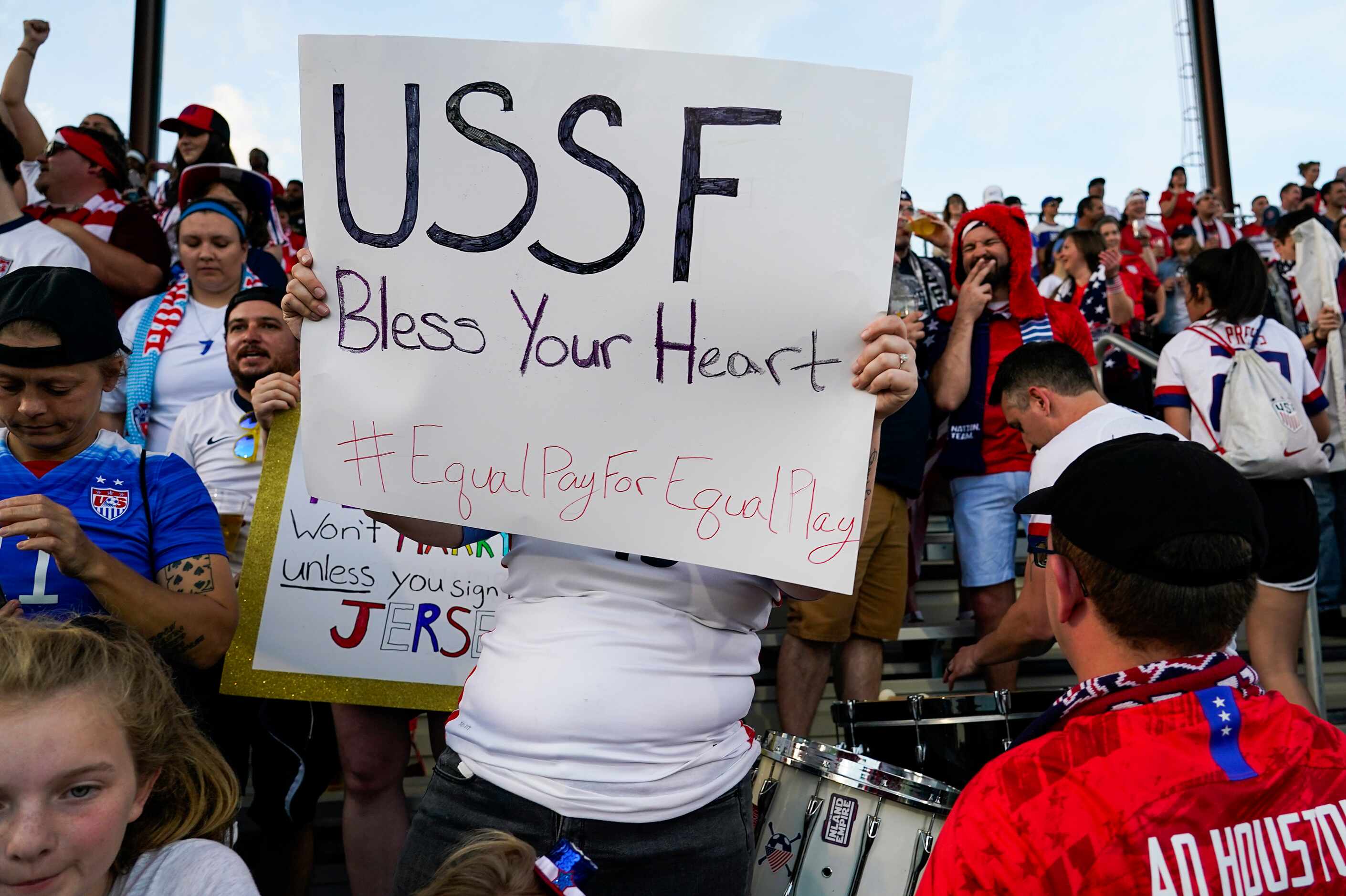 A USA fan holds a sign calling for equal pay for the womenÕs national team before a...