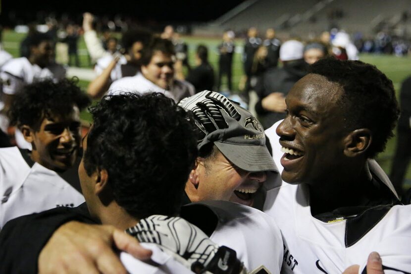 Plano East head coach Joey McCullough celebrates with wide receiver Audie Omotosho (right)...