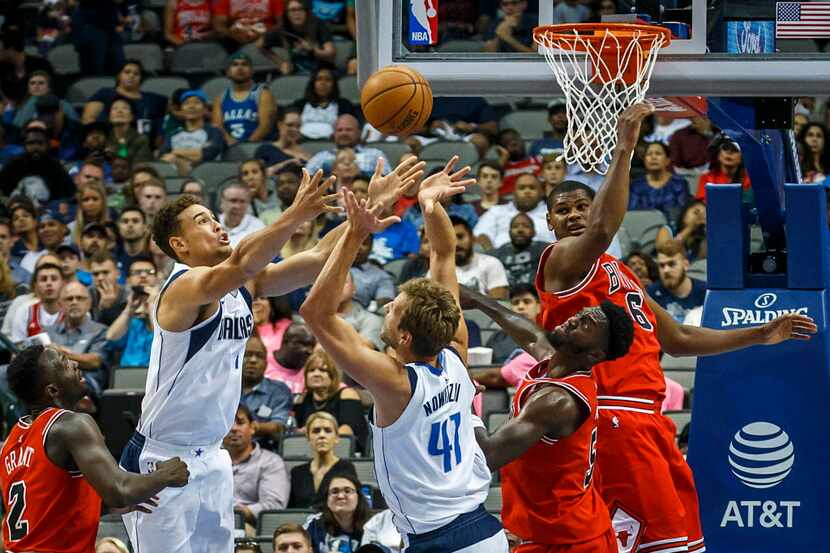 Dallas Mavericks forwards Dirk Nowitzki (41) and Dwight Powell (7) fight for a rebound...