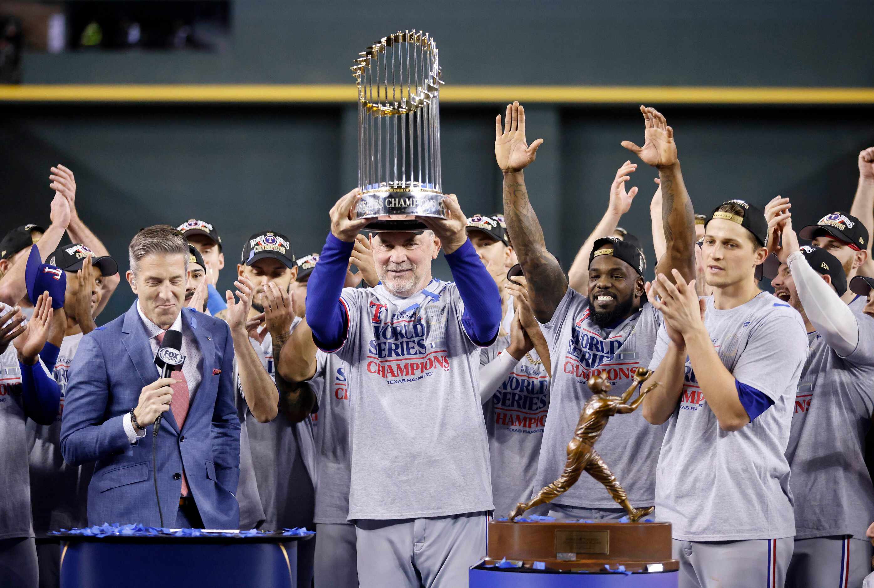 Texas Rangers manager Bruce Bochy hoists the World Series trophy at Chase Field in Phoenix,...