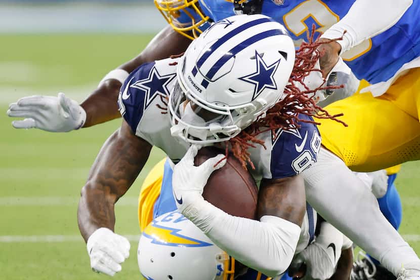 Dallas Cowboys wide receiver CeeDee Lamb (88) is tackled by a trio of Los Angeles Chargers...