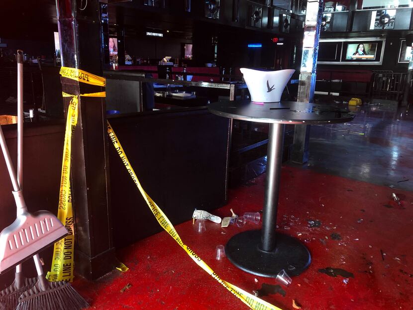 Crime scene tape and debris littered the Pryme Bar in northwest Dallas on Saturday morning....