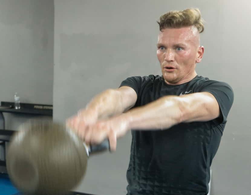 Troy Smits swings a kettlebell during a high intensity workout.
