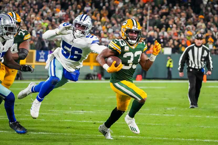 Green Bay Packers running back Aaron Jones (33) gets past Dallas Cowboys defensive end Dante...