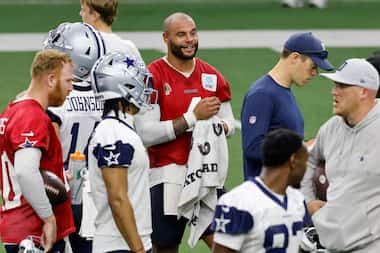 Dallas Cowboys quarterback Dak Prescott (4) talks with teammates during the team's OTA...