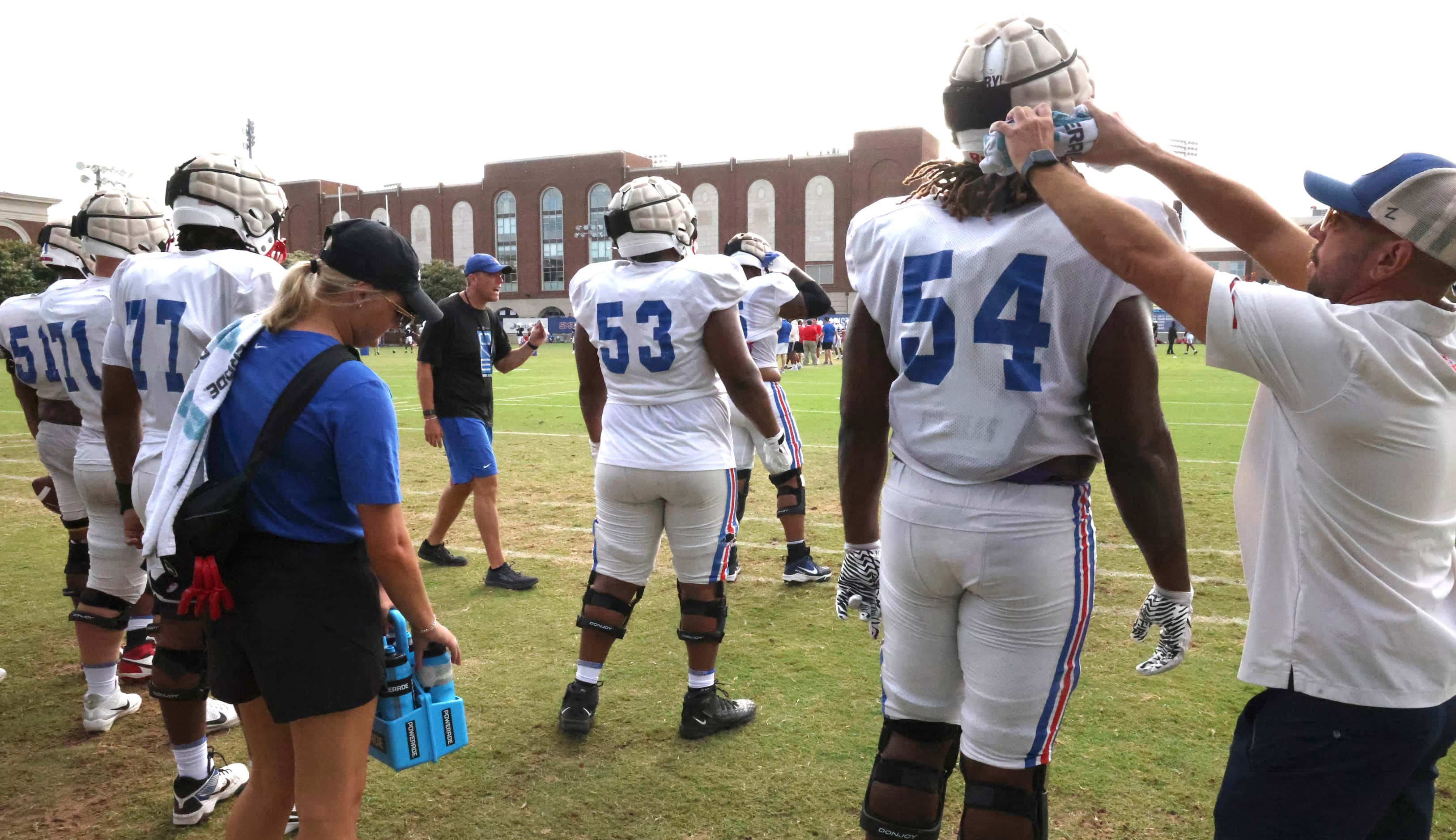 An SMU trainer applies water to the neck of offensive lineman Savion Byrd (54), a...