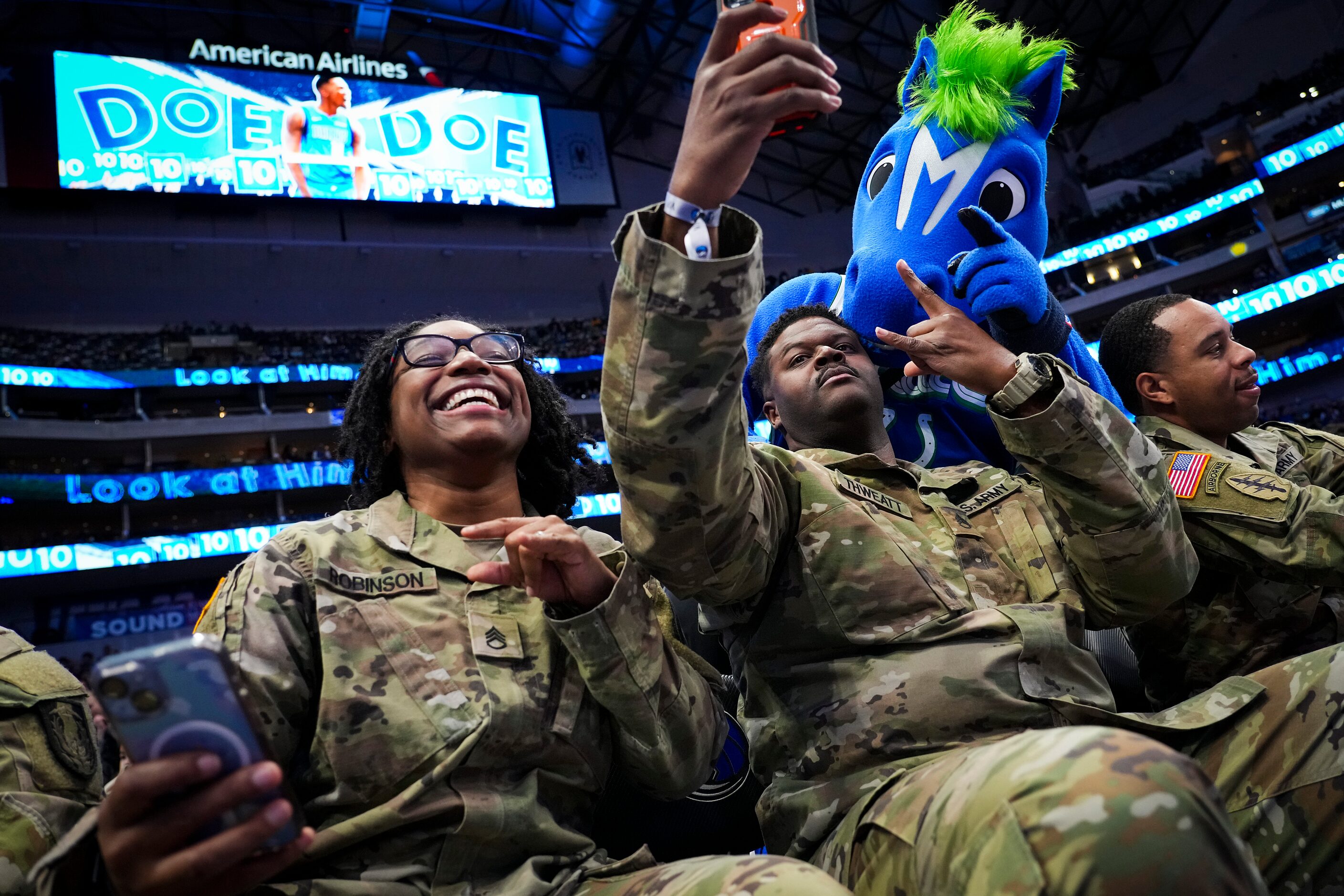 Staff Sgt. Beonka Robinson and Staff Sgt. Brandon Thweatt take selfies with Dallas Mavericks...