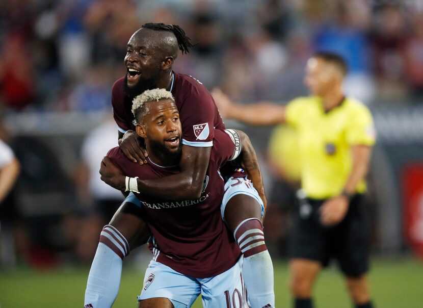 Colorado Rapids forward Kei Kamara, top, jumps on midfielder Kellyn Acosta after he scored a...