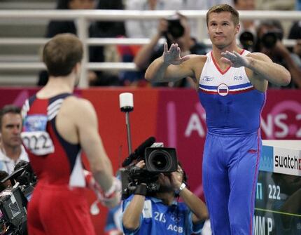 lexei Nemov of Russia tries to quiet the crowd as Paul Hamm waits to perform on  the...