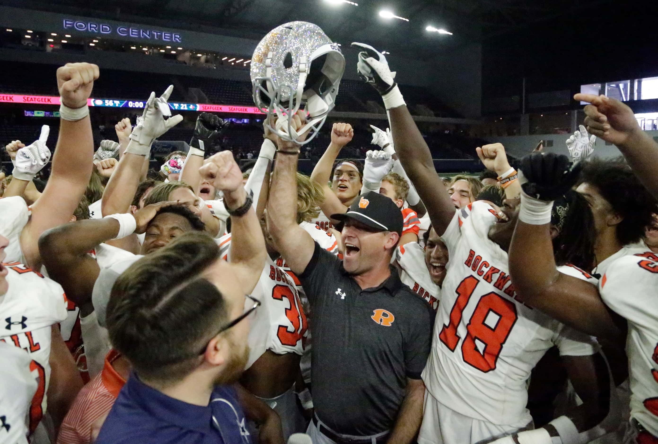 Rockwall High School head coach Trey Brooks holds up the Jerry Jones Classic trophy after...