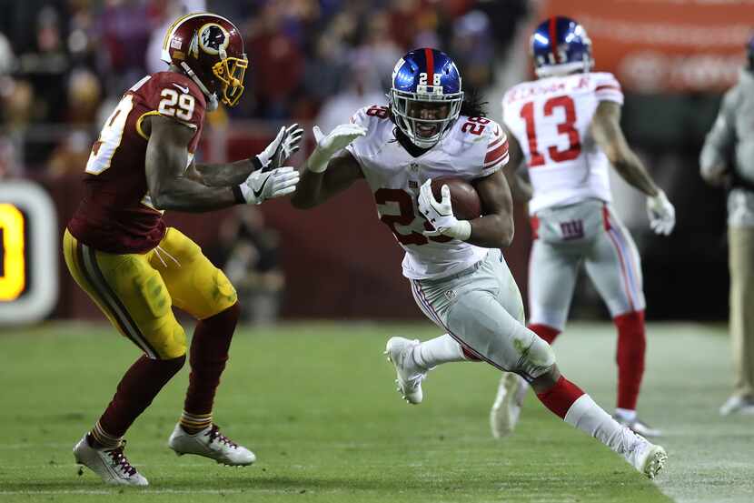 LANDOVER, MD - JANUARY 01: Running back Paul Perkins #28 of the New York Giants carries the...