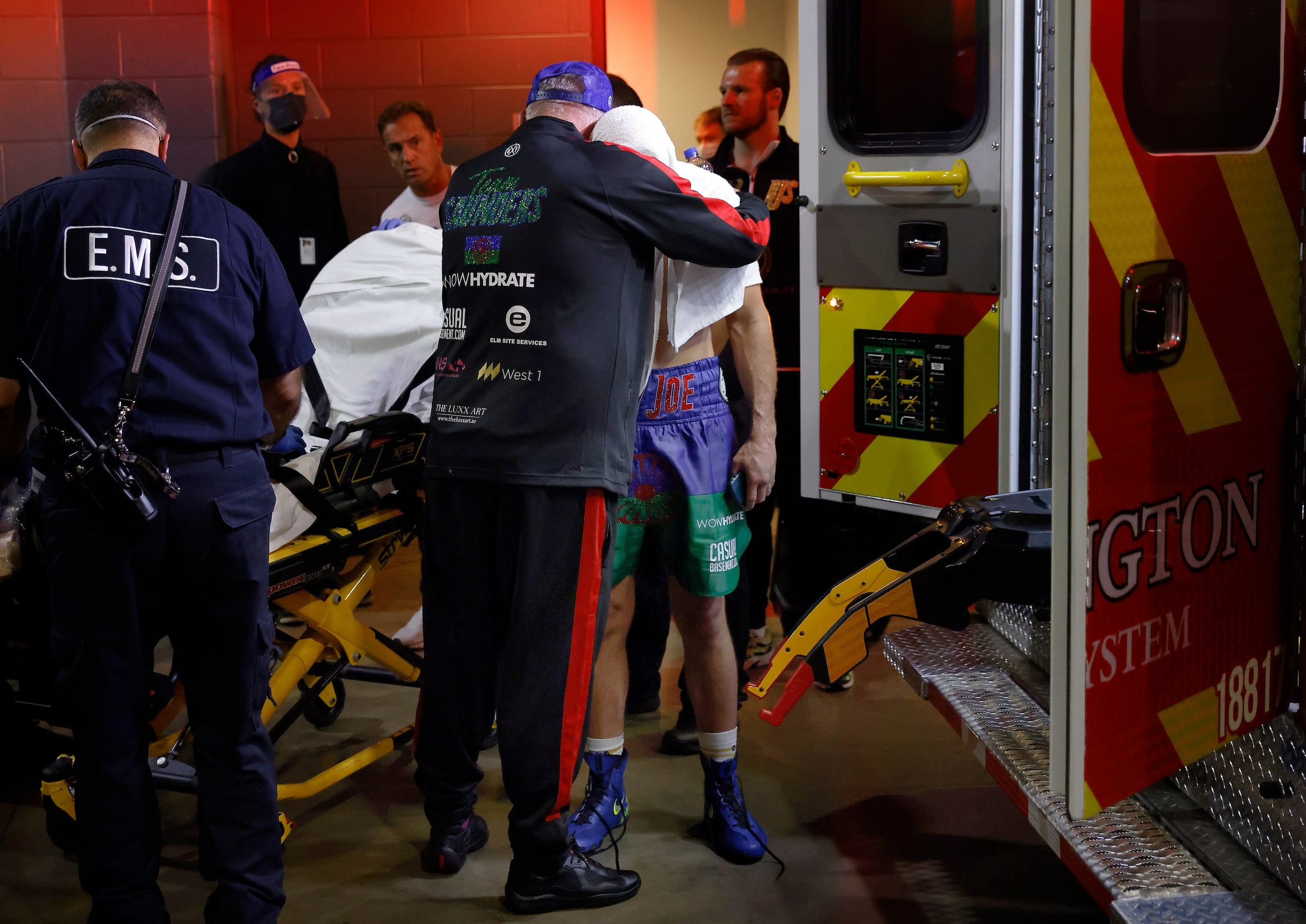 Boxer Billy Joe Saunders receives a hug from a team member as he waits to board an ambulance...