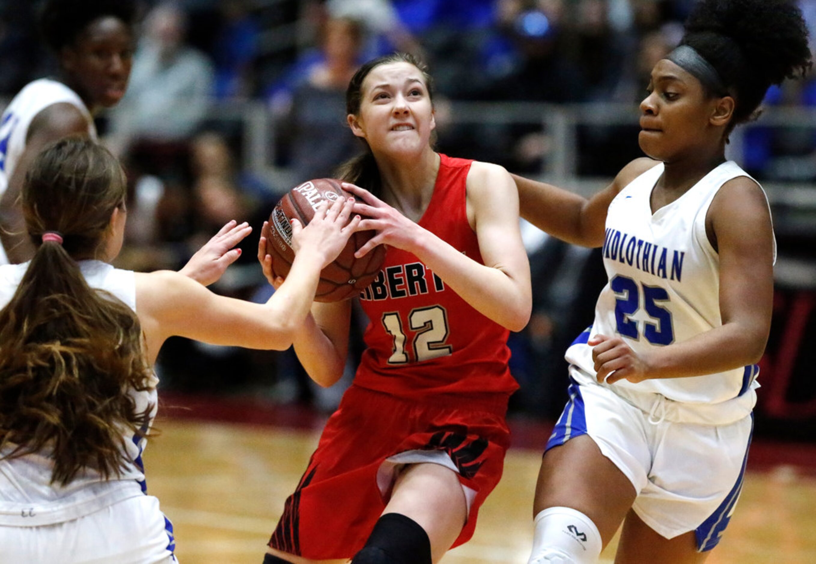 Frisco Liberty High School guard Ashley Anderson (12) drives between Midlothian High School...