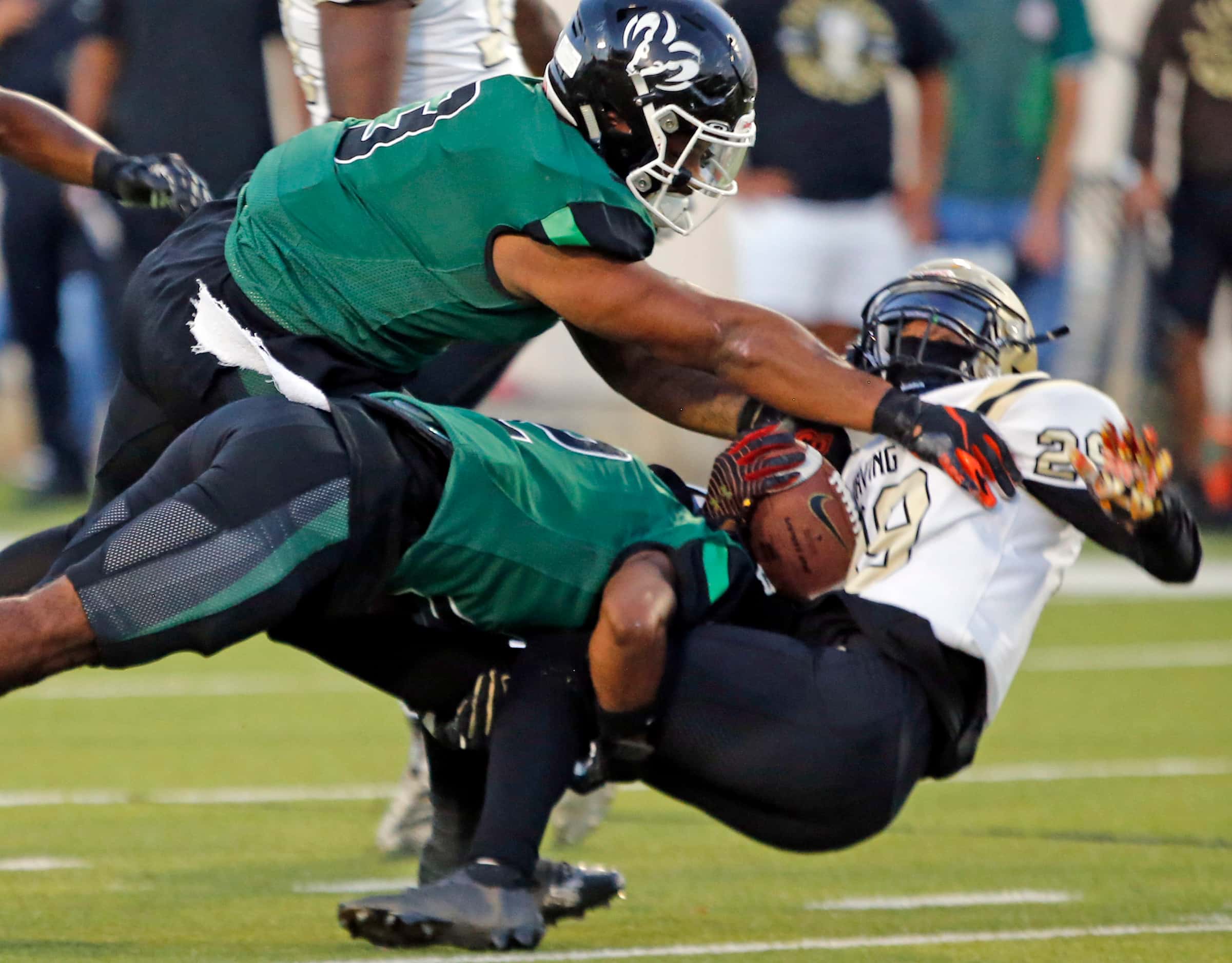 Irving high’s Napoleon Proctor (29) is stopped by Richardson Berkner high defenders during...