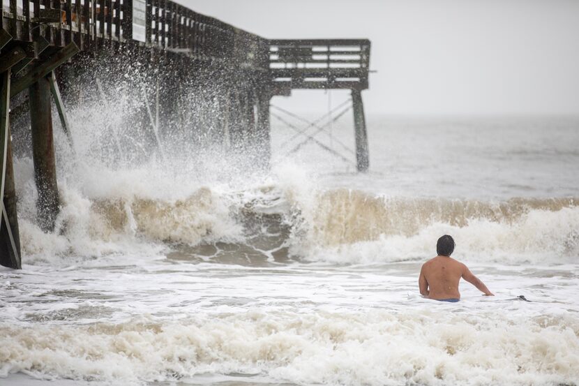 Un surfista intenta aprovechar las consecuencias del paso de la tormenta tropical Debby, el...