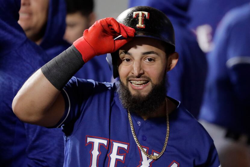 Texas Rangers' Rougned Odor smiles in the dugout after he scored a run on a double by Ronald...