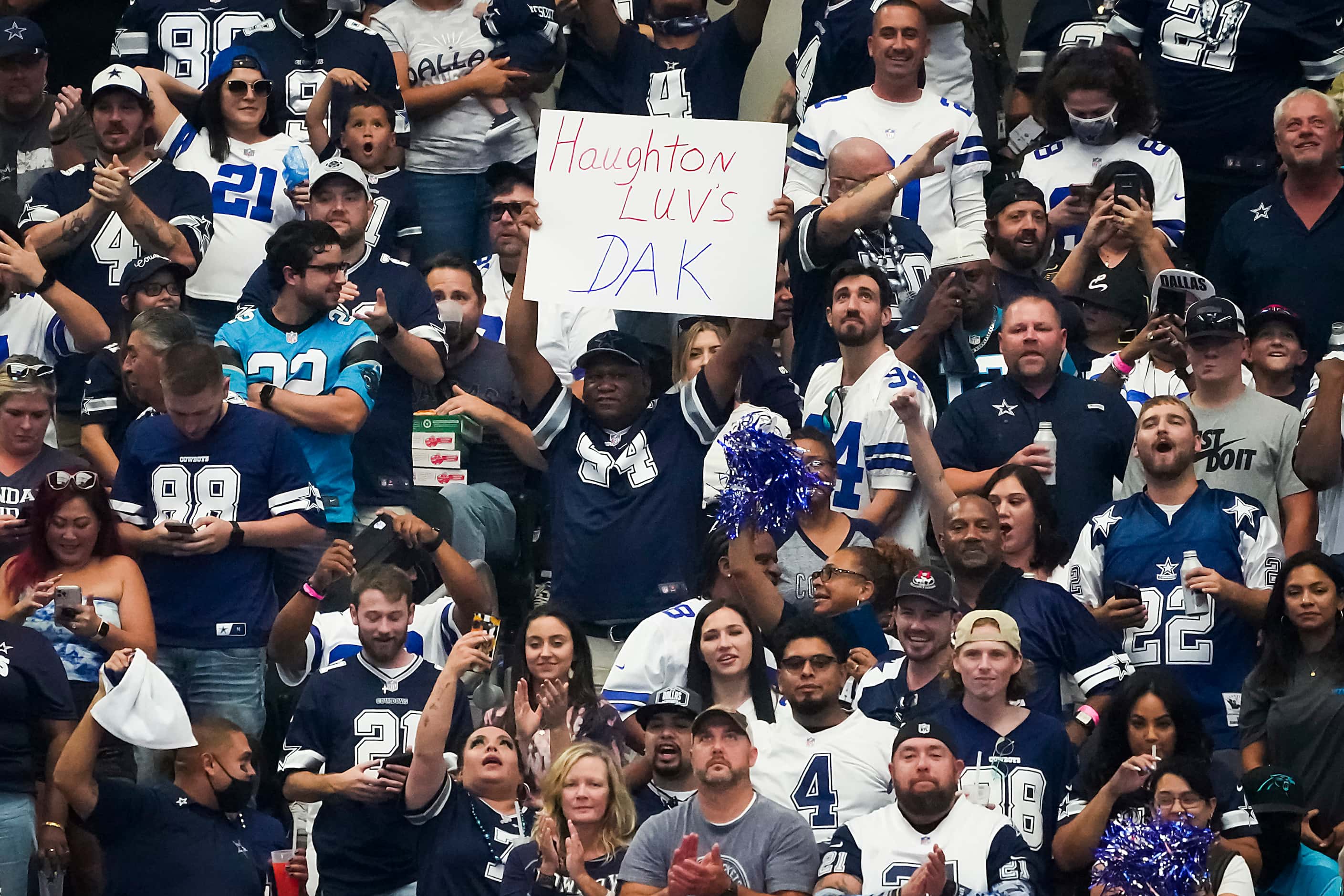 Fan cheer Dallas Cowboys quarterback Dak Prescott, including one holding a sign of support...