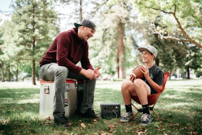 Father and son sit outside while talking