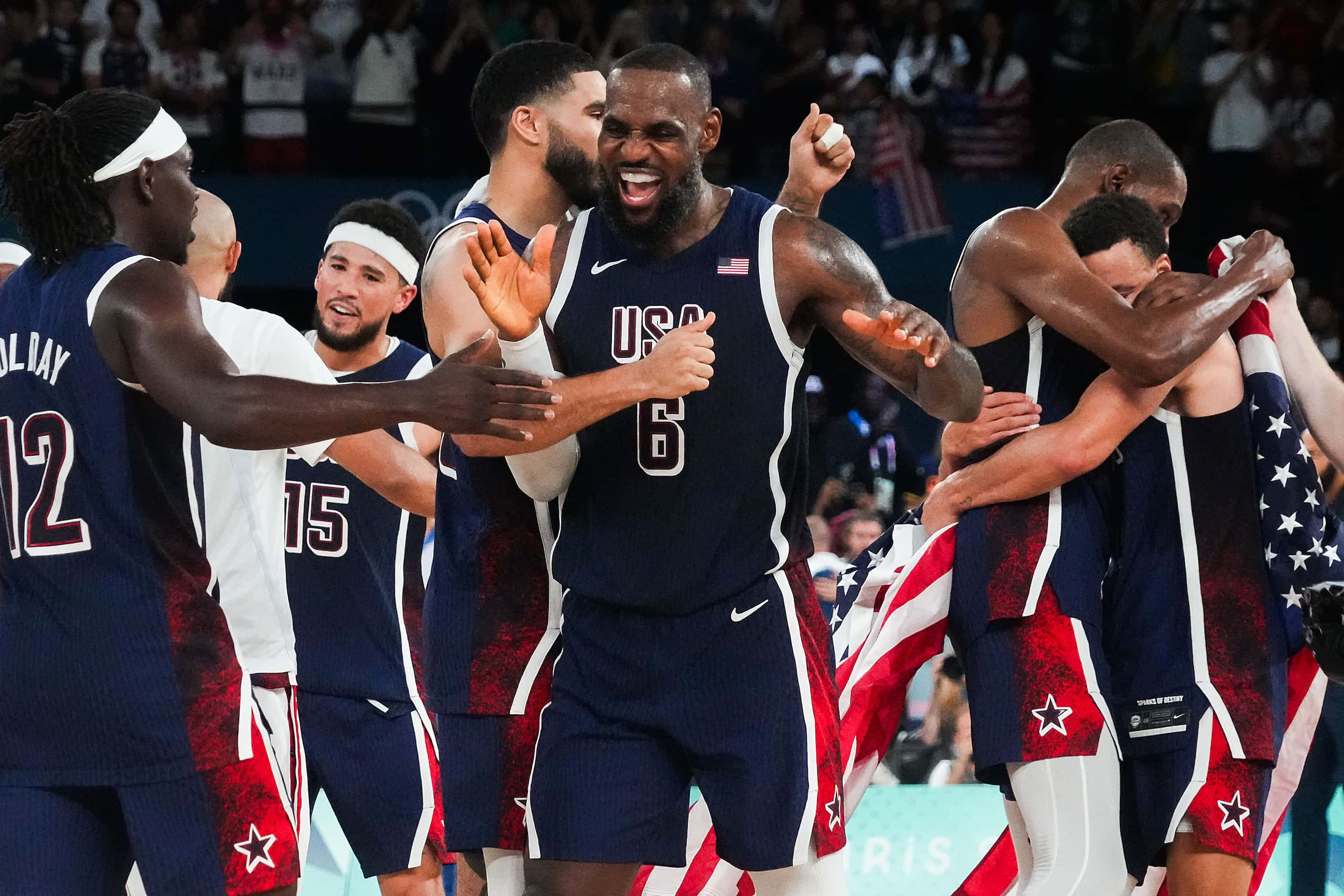 Lebron James (6) of the United States celebrates with teammates after a victory over France...