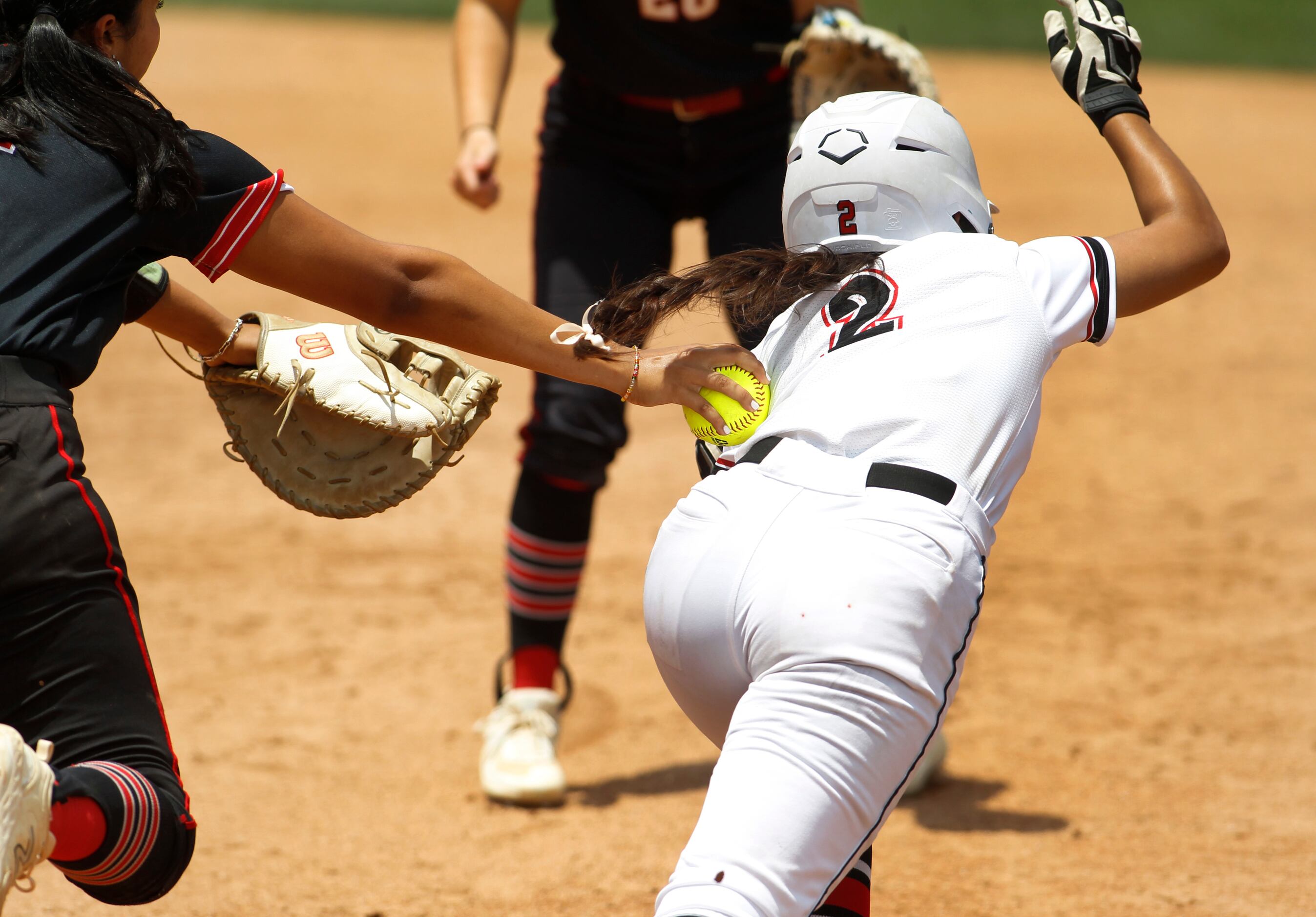 Colleyville Heritage shortstop Nia Sisneros (2) is tagged out by Comal Canyon first baseman...