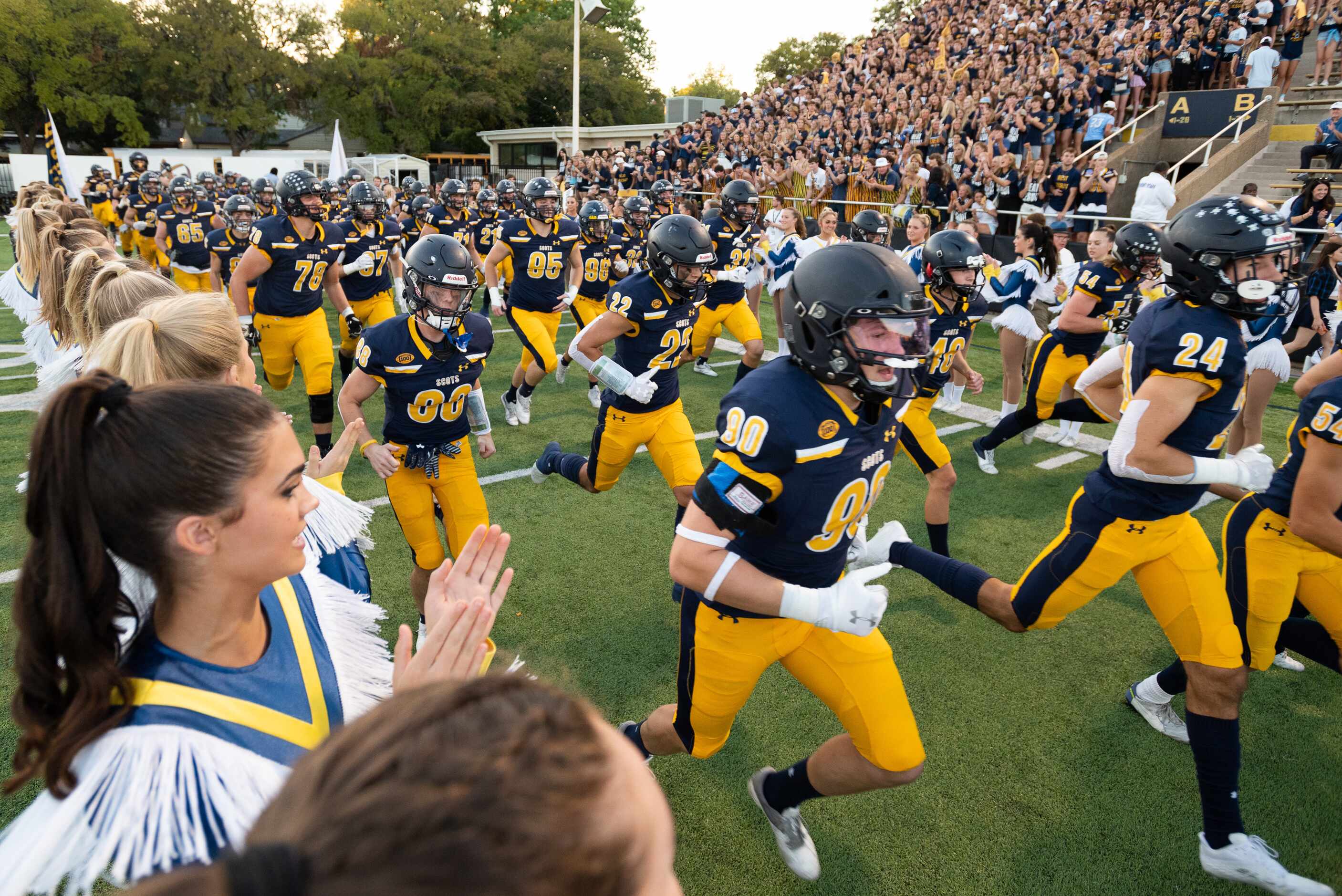 Highland Park football players run on to the field for their Friday night high school game...