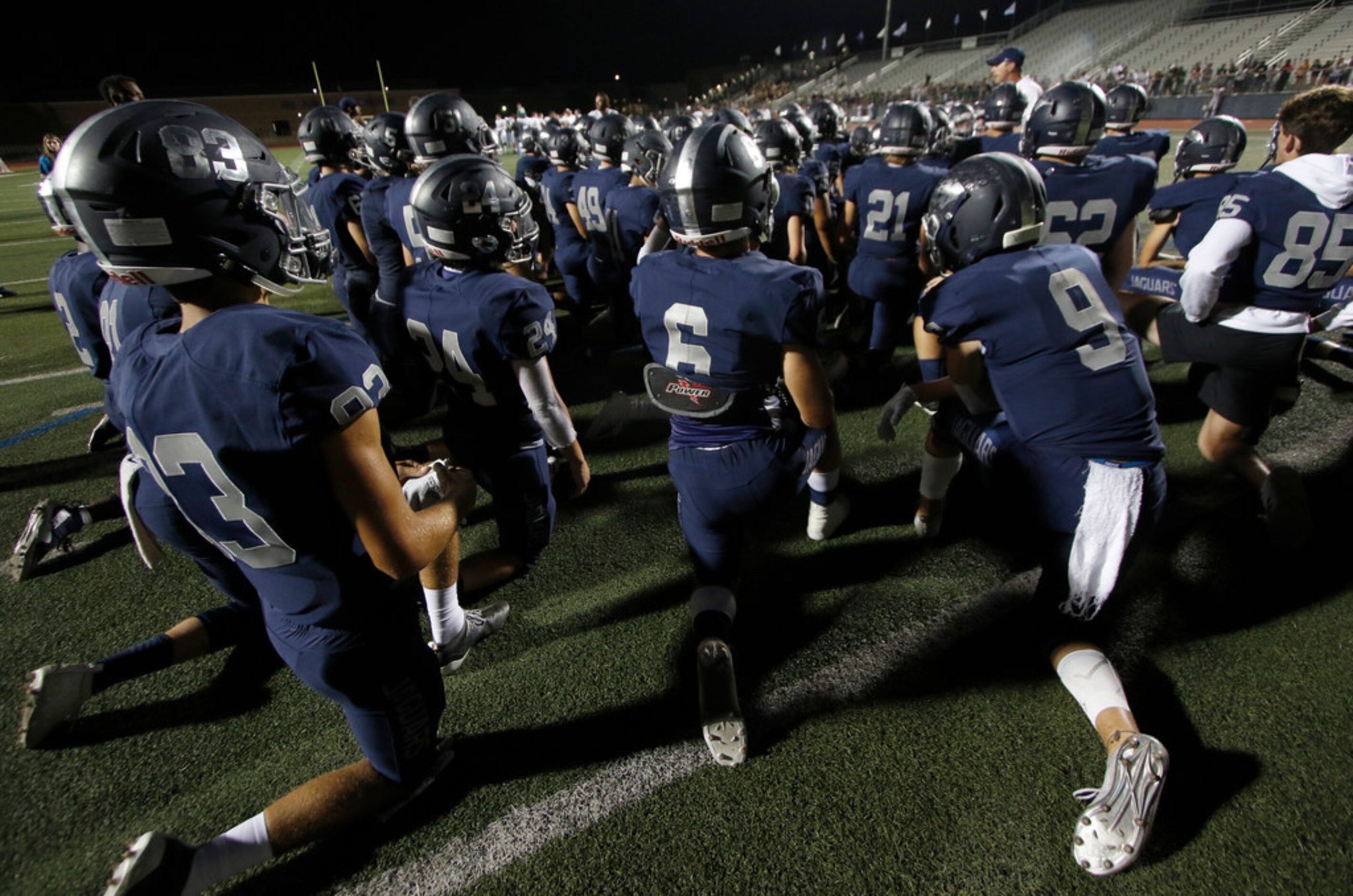 Carson Winters (9) takes a knee with teammates for words of encouragement from the coaching...