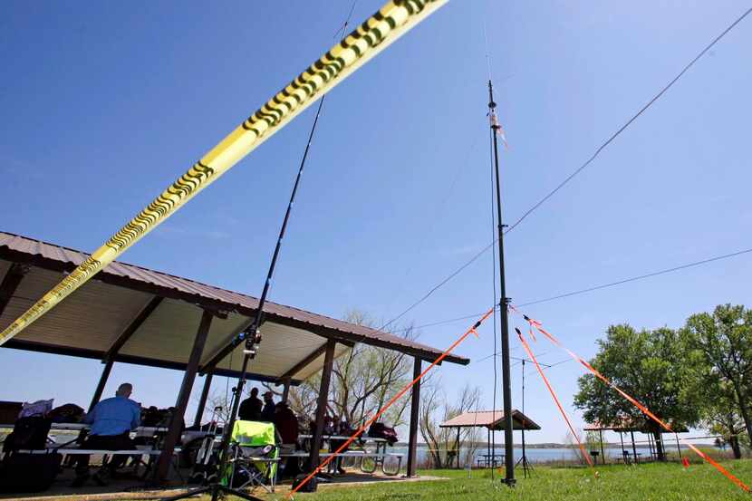 
Yellow caution tape surrounds a variety of antennas set up to reach radio users ranging...