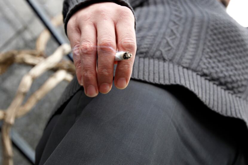 Nathan Morgan smokes a cigarette during a break from work outside the Renaissance Tower in...