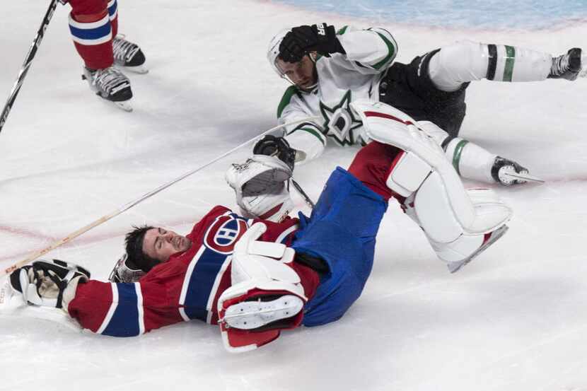 Montreal Canadiens goalie Carey Price lies on the ice after taking a hit from Dallas Stars'...
