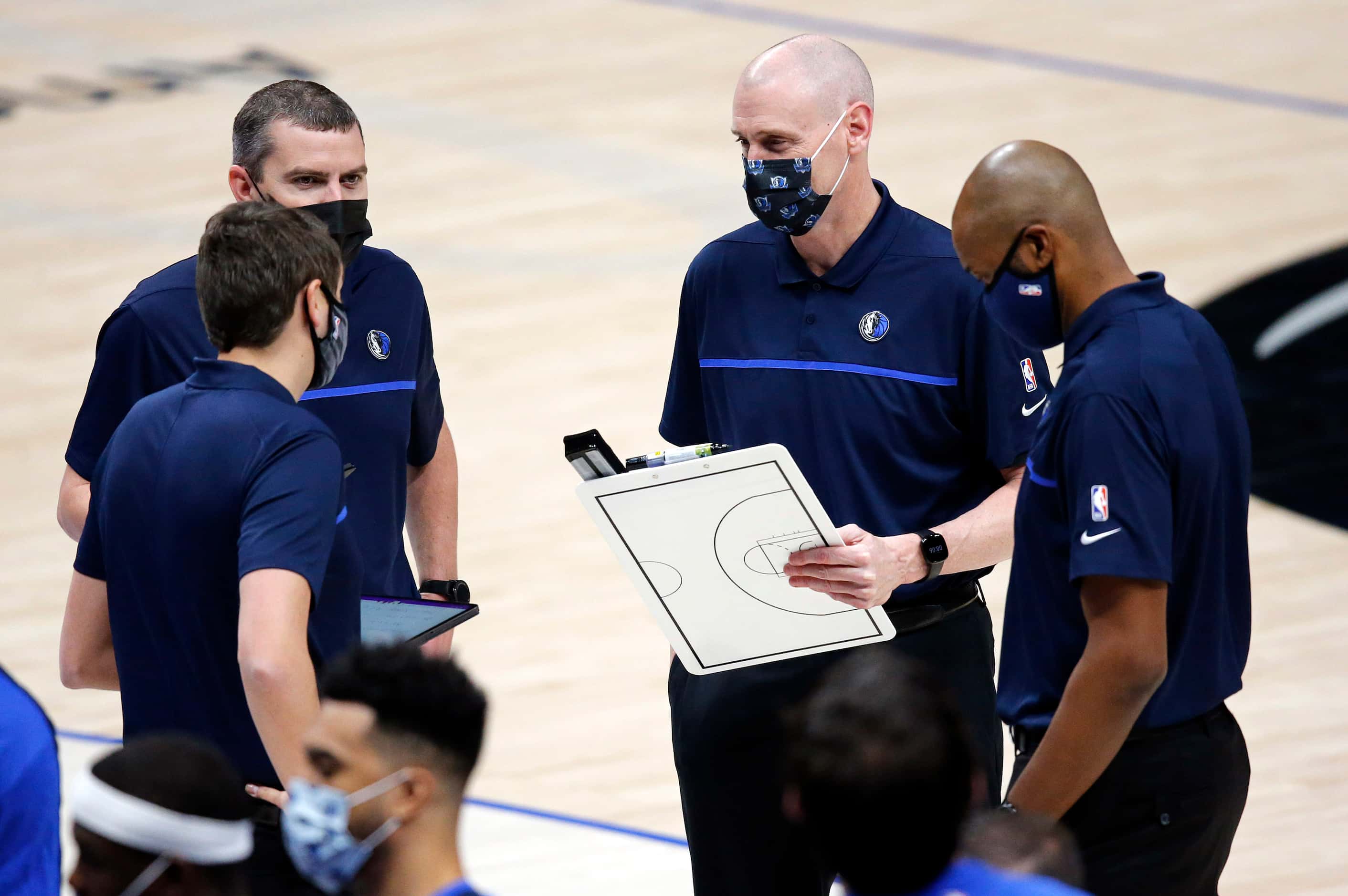 Dallas Mavericks head coach Rick Carlisle (second from right) talks with his coaches during...