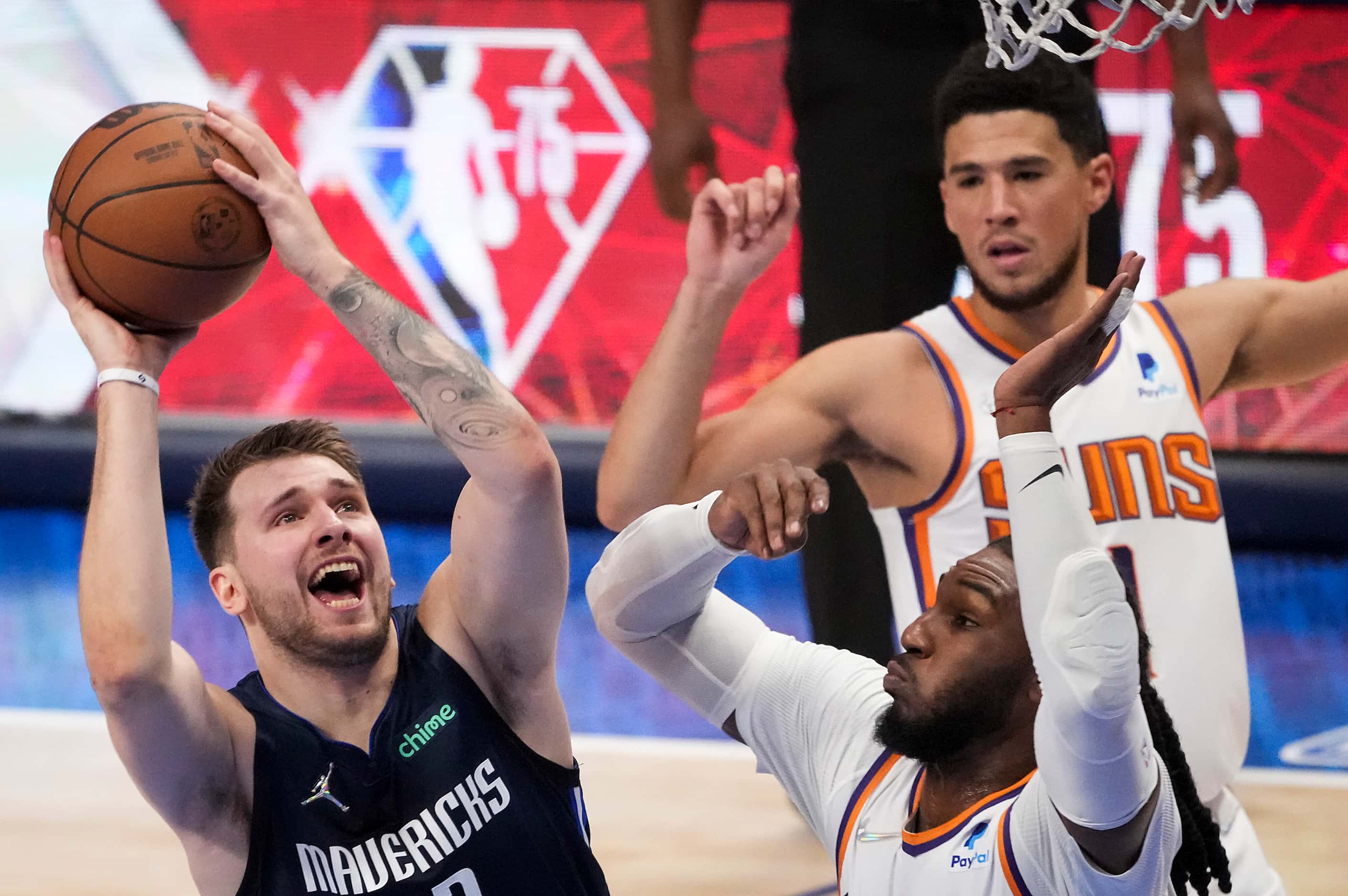 Dallas Mavericks guard Luka Doncic (77) puts up a shot as Phoenix Suns forward Jae Crowder...