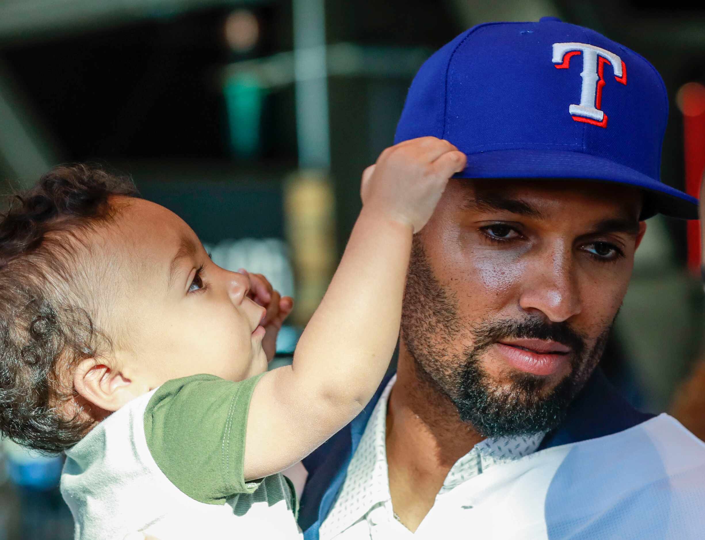 Marcus Semien holds his child at a news conference at Globe Life Park in Arlington on...