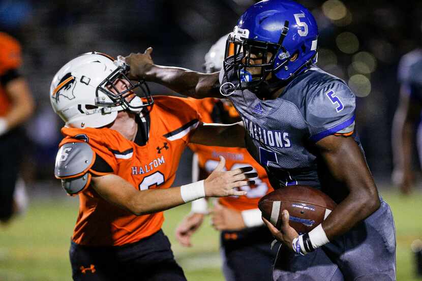 TXHSFB North Mesquite senior quarterback Kamaury Thompson (5), right, battles Haltom City...