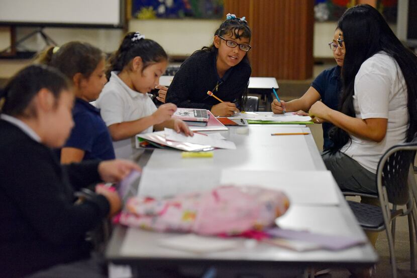 Fourth-graders Angie Zamacona (left) and Hellen Trujillo work on their math homework with...