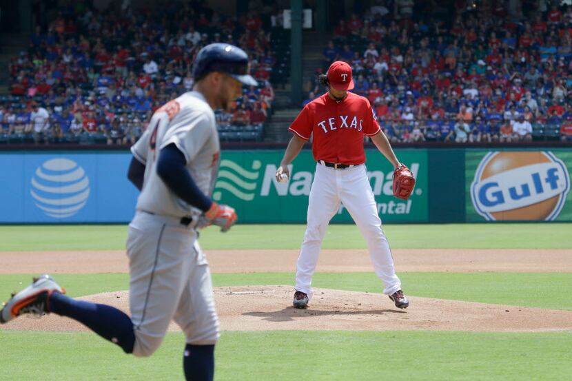 Houston Astros' George Springer, left, runs out his solo home run off Texas Rangers starting...