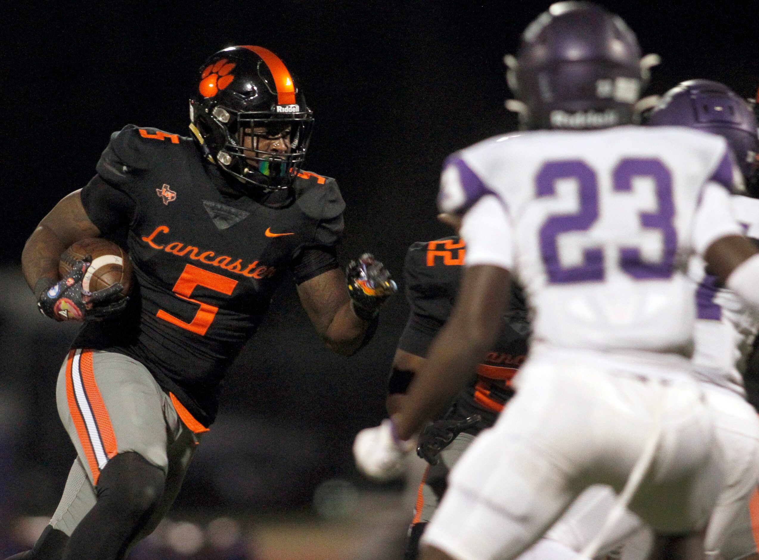 Lancaster running back Mar'kel Porter (5), left, looks for a running lane as he is pursued...