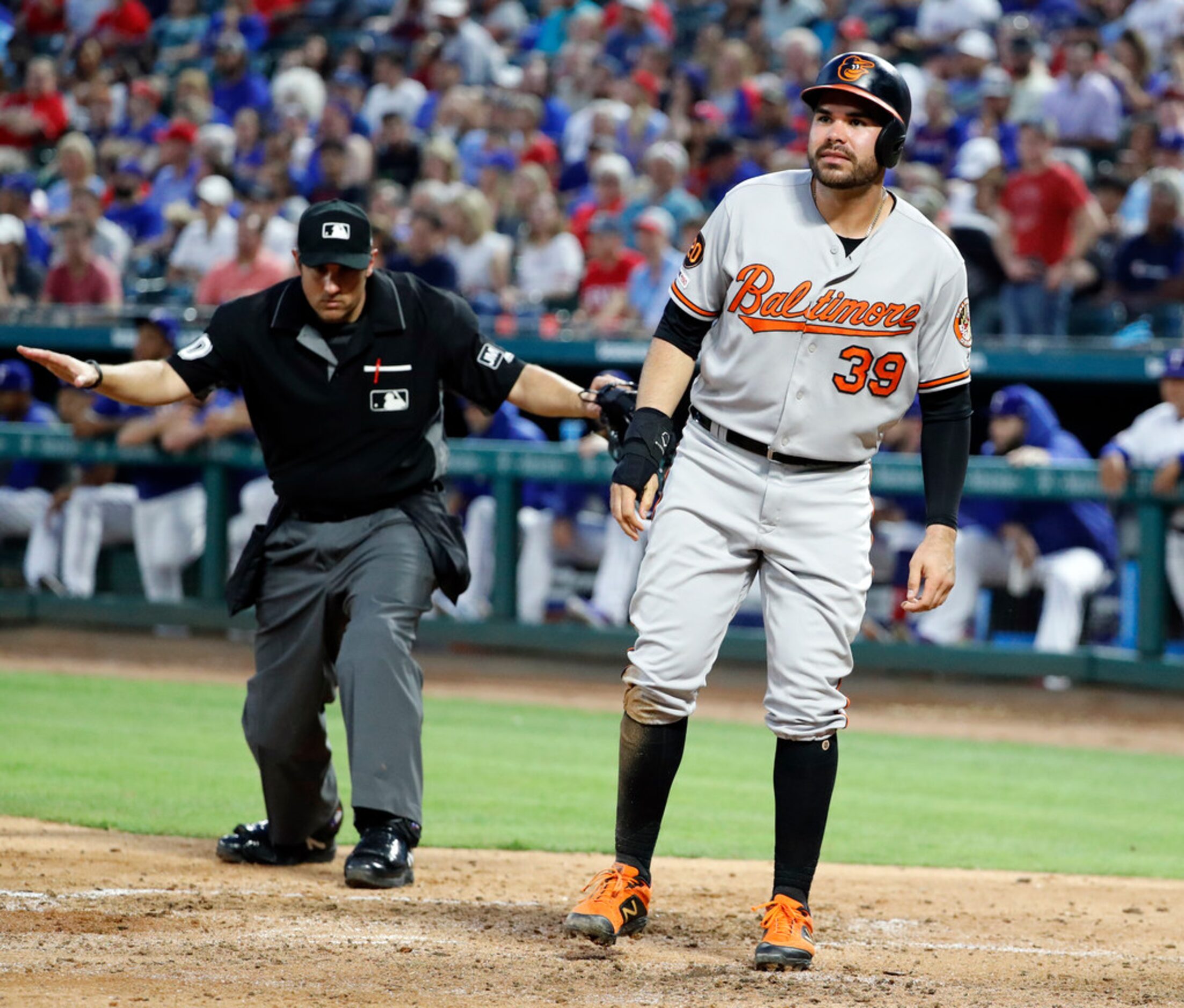 Home plate umpire Mark Ripperger signals safe, as Baltimore Orioles' Renato Nunez (39)...