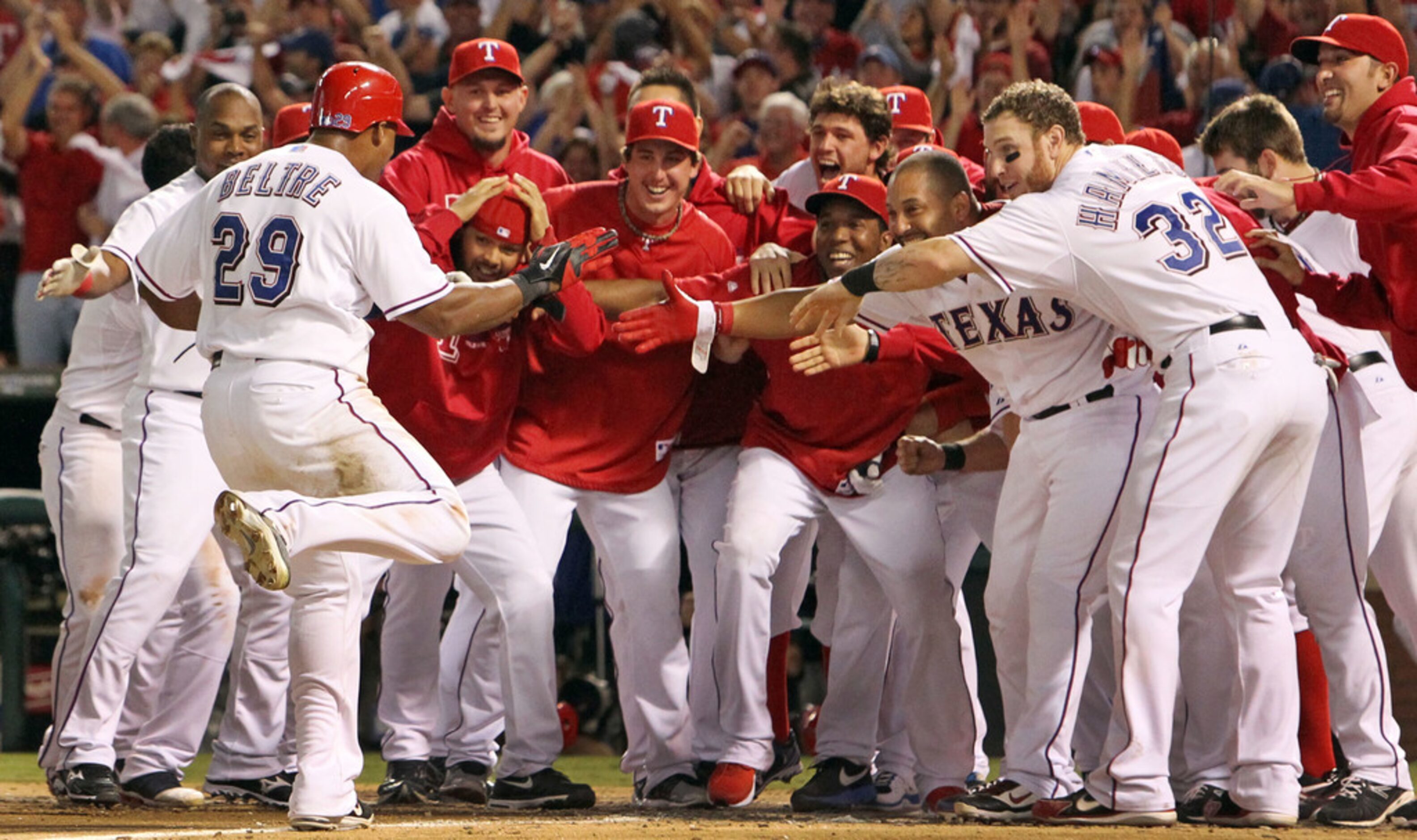 Texas' Adrian Beltre (29) is mobbed by teammates as he scores  on Nelson Cruz's walk-off...