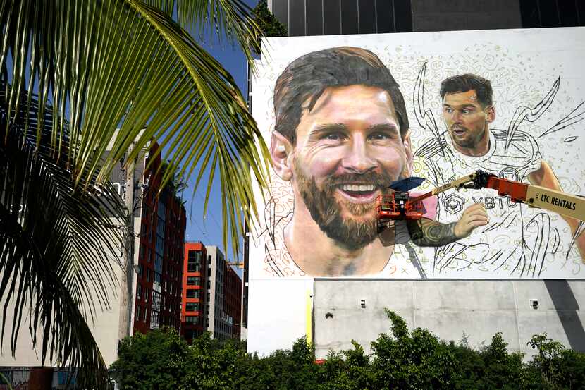 Artist Maximiliano Bagnasco paints a mural of Argentine soccer star Lionel Messi, Monday,...