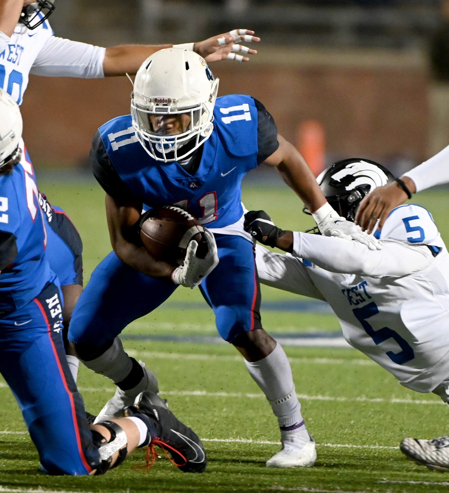 Allen’s Jordan Johnson (11) runs through a tackle attempt by Plano West’s Aaron Jones (5) in...