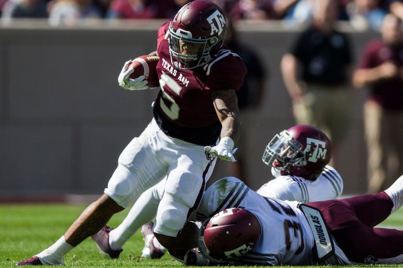 Texas A&M running back Trayveon Williams (5) is tackled by A&M linebacker Santino Marchiol...