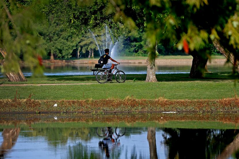 A man rides a bicycle at Towne Lake Recreation Area in McKinney, Texas, Tuesday, July 17,...