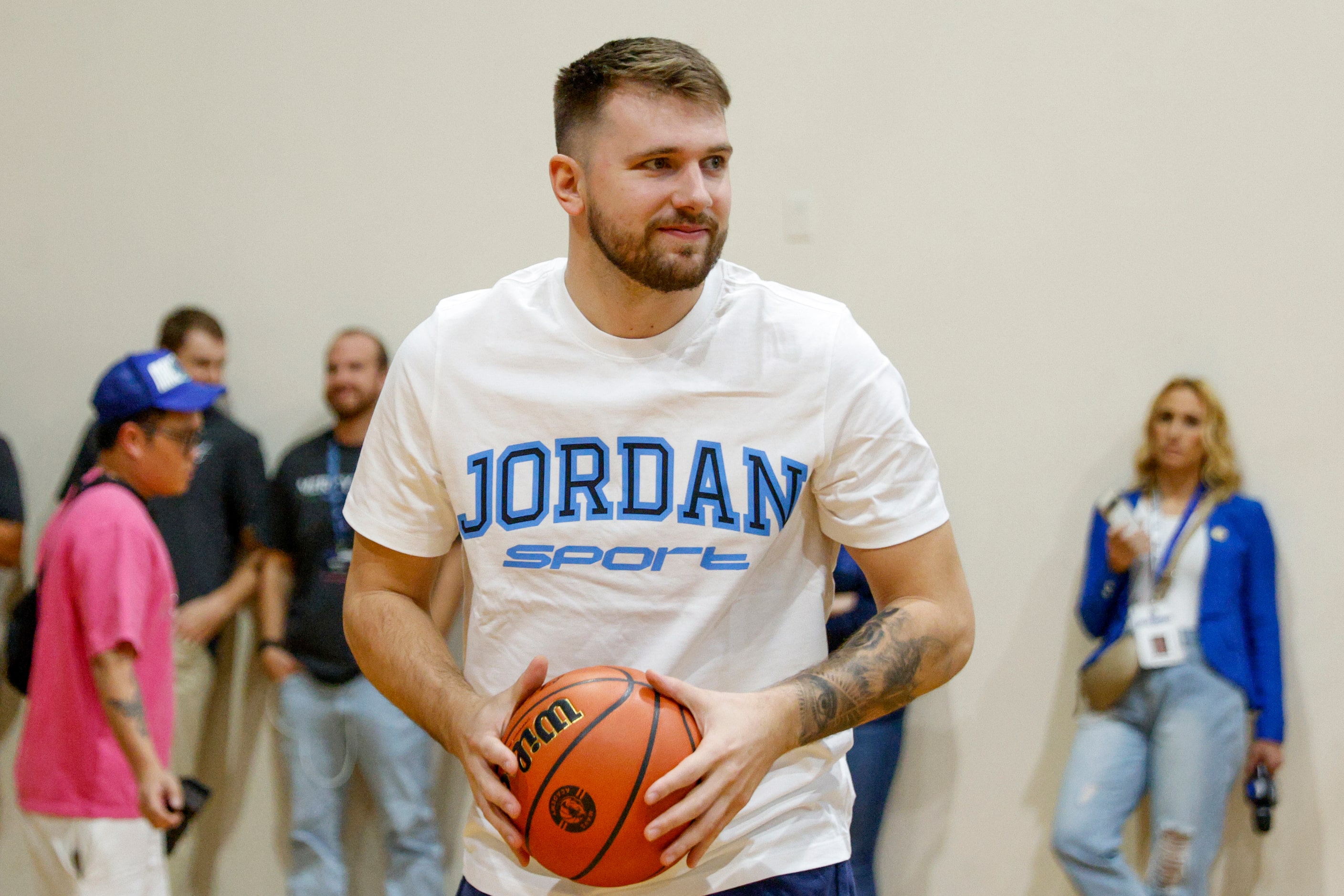 Dallas Mavericks guard Luka Doncic watches kids practice basketball drills during a clinic,...