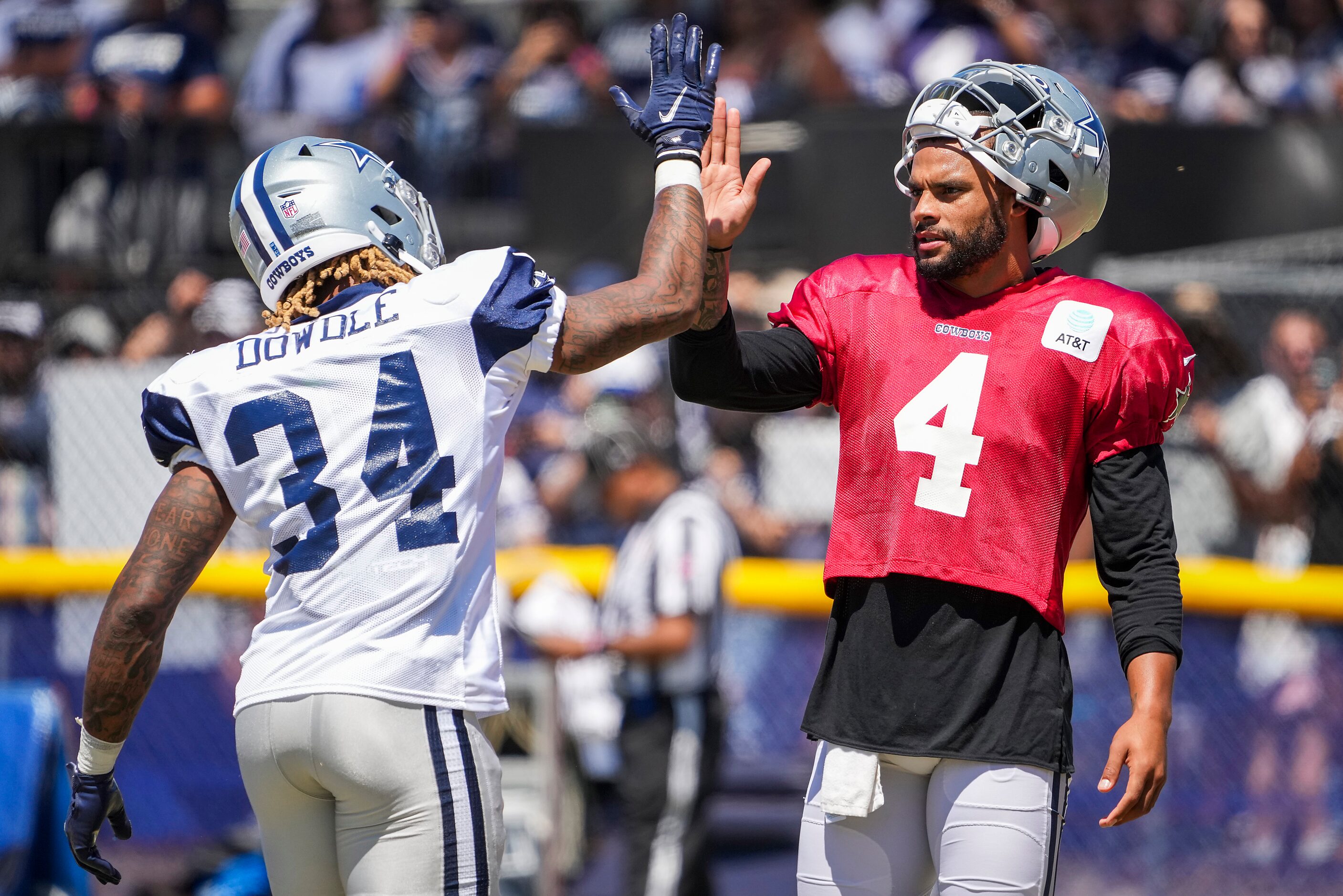 Dallas Cowboys quarterback Dak Prescott (4) high fives running back Rico Dowdle (34) during...