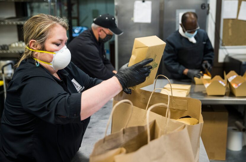 From left, Trisha Snell, John Gilbert, and Bill Jordan of G-Texas Custom Catering pack box...