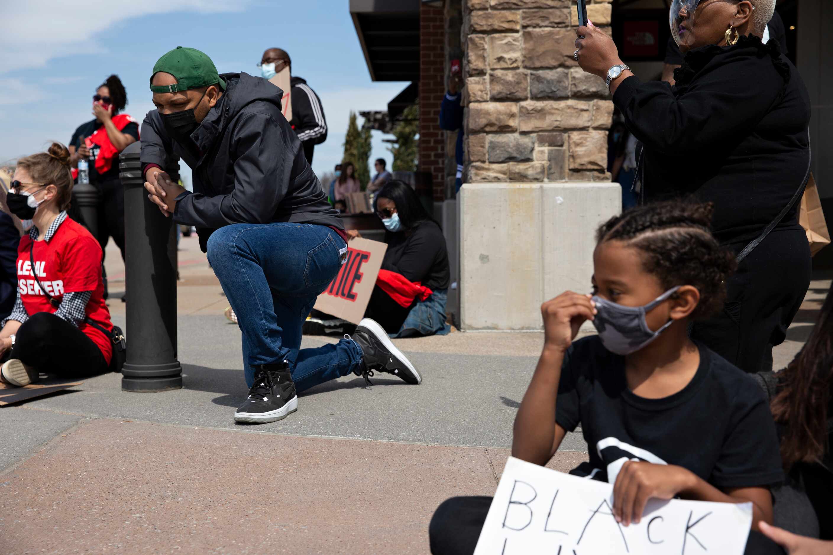 Carl Sherman Jr. takes a knee at the Allen Outlets on Sunday, March 21, 2021 during a march...