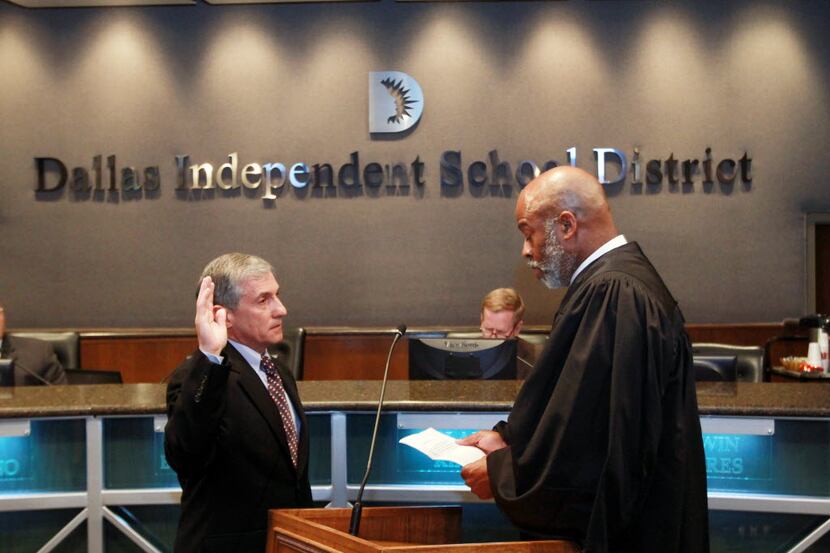 Judge Eric Moyé, right, swears in new Dallas school board trustee Dan Micciche on May 24,...