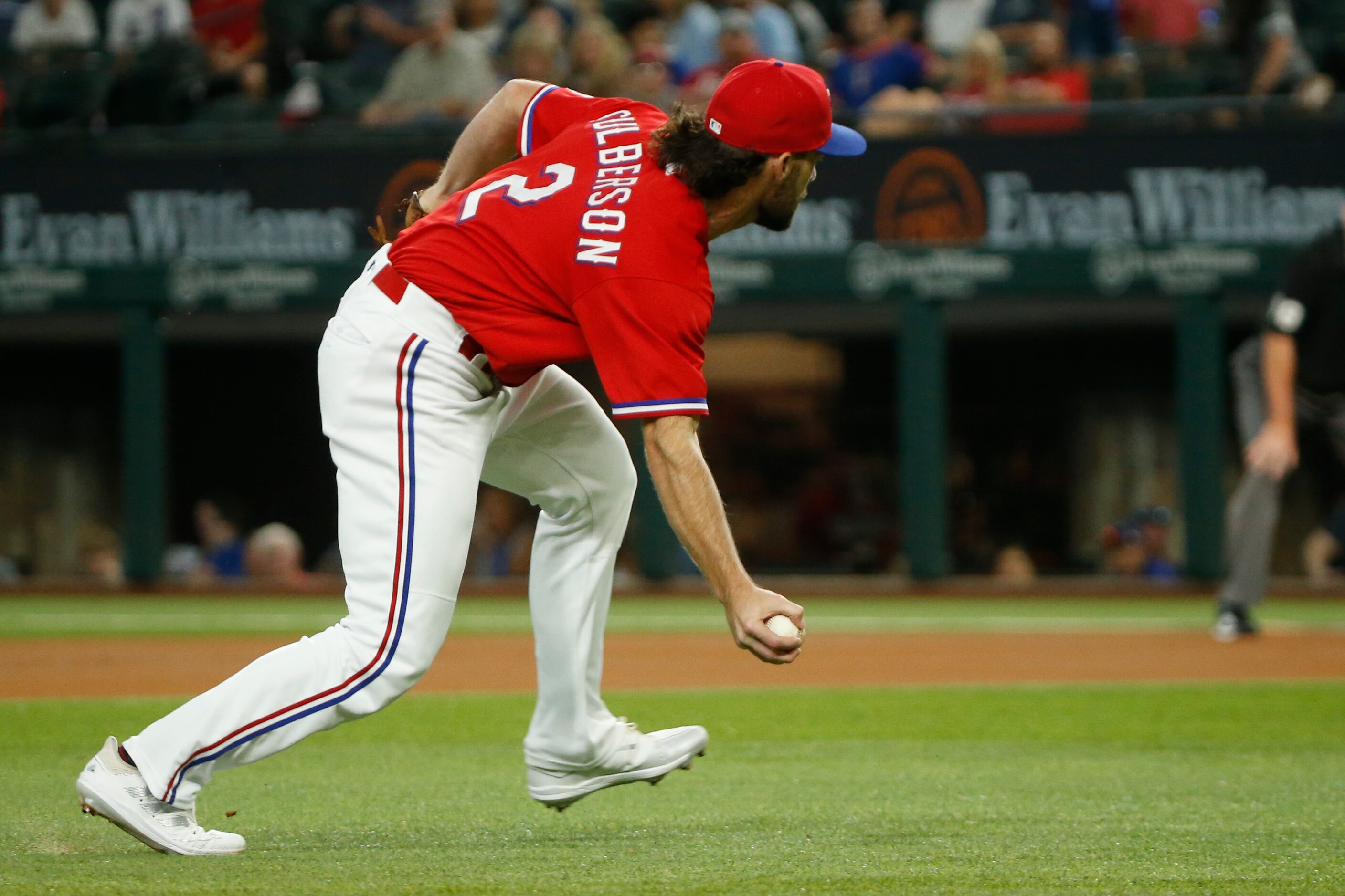 Texas Rangers third baseman Charlie Culberson (2) fields the ball barehanded before throwing...