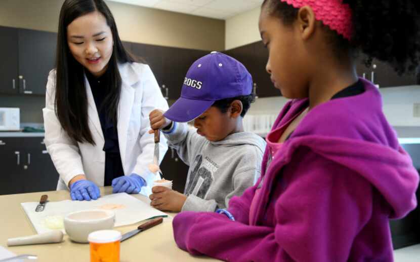 Pharmacy Technology student Victoria Ngo helps Tristin and Leah Jackson make an ointment.